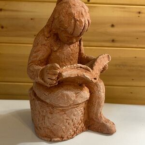 Local artist clay girl reading.